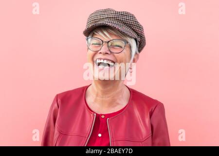 Bonne femme senior qui s'amuse en plein air - personne mûre à la mode riant et profitant du temps de retraite - personnes âgées style de vie et le concept de jour de la mère Banque D'Images