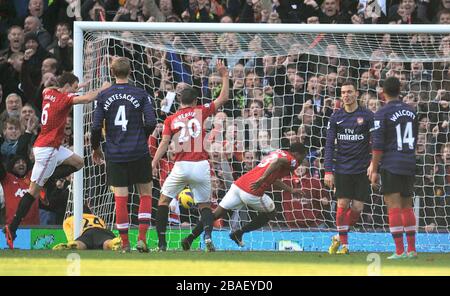 Patrice Evra (au centre) de Manchester United célèbre son deuxième but du jeu alors que les défenseurs d'Arsenal sont déjectés Banque D'Images