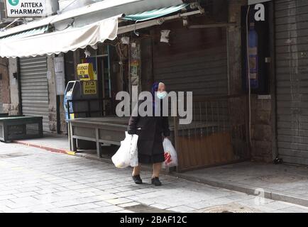 Jérusalem, Israël. 27 mars 2020. Un israélien porte un masque de protection dans le marché de Mahane Yehuda à Jérusalem, dont la clôture est en cours, le vendredi 27 mars 2020. Onze Israéliens sont morts du coronavirus, alors que plus de 3 000 ont été diagnostiqués avec la maladie. Le gouvernement israélien a imposé de sévères restrictions de mouvement, laissant seulement des magasins essentiels ouverts dans un effort pour arrêter la propagation du coronavirus. Photo par Debbie Hill/UPI crédit: UPI/Alay Live News Banque D'Images