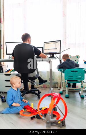 Père avec enfants essayant de travailler de la maison pendant la quarantaine. Restez à la maison, travaillez à partir du concept de maison pendant la pandémie de coronavirus Banque D'Images