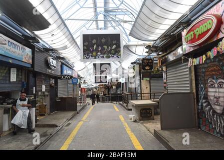 Jérusalem, Israël. 27 mars 2020. Un vendeur israélien se trouve en dehors de son magasin à moitié fermé dans le marché de Mahane Yehuda à Jérusalem, le vendredi 27 mars 2020. Onze Israéliens sont morts du coronavirus, alors que plus de 3 000 ont été diagnostiqués avec la maladie. Le gouvernement israélien a imposé de sévères restrictions de mouvement, laissant seulement des magasins essentiels ouverts dans un effort pour arrêter la propagation du coronavirus. Photo par Debbie Hill/UPI crédit: UPI/Alay Live News Banque D'Images