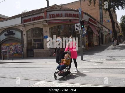 Jérusalem, Israël. 27 mars 2020. Les Israéliens portent des masques de protection tout en marchant dans une rue vide à Jérusalem, le vendredi 27 mars 2020. Onze Israéliens sont morts du coronavirus, alors que plus de 3 000 ont été diagnostiqués avec la maladie. Le gouvernement israélien a imposé de sévères restrictions de mouvement, laissant seulement des magasins essentiels ouverts dans un effort pour arrêter la propagation du coronavirus. Photo par Debbie Hill/UPI crédit: UPI/Alay Live News Banque D'Images