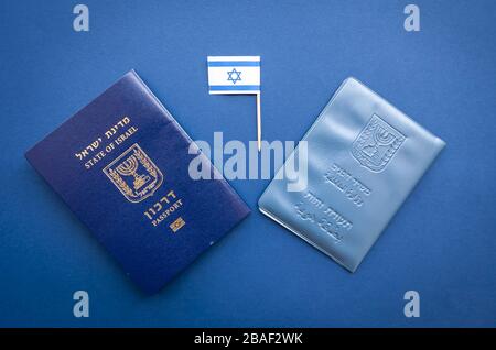 Documents officiels israéliens : passeport d'Israël et document d'identité national sur fond bleu avec un petit drapeau d'Israël. Concept de citoyenneté israélienne Banque D'Images