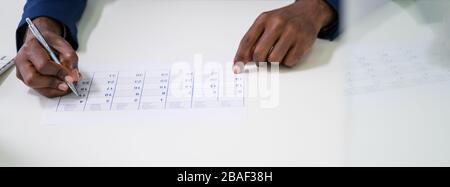 Gros plan sur les hommes d'affaires marquant UNE journée dans le calendrier Banque D'Images