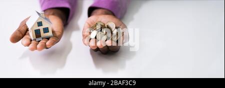 Close-up of a Man's Hand Holding House Model et des pièces plus de 24 Banque D'Images