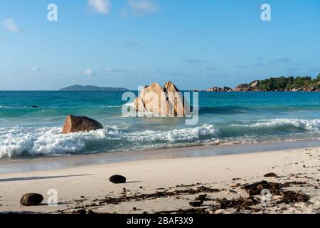 Jeunes femmes assis sur la plage d'Anse petit à l'île Mahe Seychelles Banque D'Images