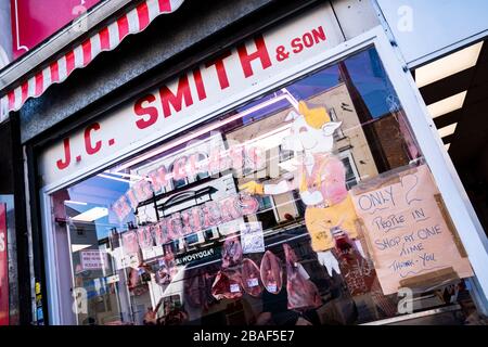 Les entreprises de Deptford High St, Londres, Royaume-Uni ont limité les échanges commerciaux en raison de Coronavirus. Seulement 2 personnes sont autorisées en une seule fois. Banque D'Images