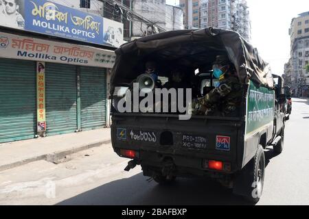 Dhaka, Bangladesh. 27 mars 2020. Les soldats de l'armée conscients que les gens en général utilisent le masque, restent à la maison lorsqu'ils patrouillent le long d'une rue lors d'un verrouillage imposé par le gouvernement comme mesure préventive contre le coronavirus COVID-19 à Dhaka le 27 mars 2020. Crédit: Alay/Alay Live News Banque D'Images