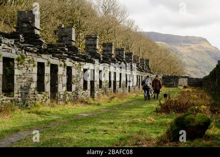 La caserne d'Anglesey - une rangée de cottages de miner à Dinorwig au nord du Pays de Galles avec deux marcheurs pour chiens Banque D'Images