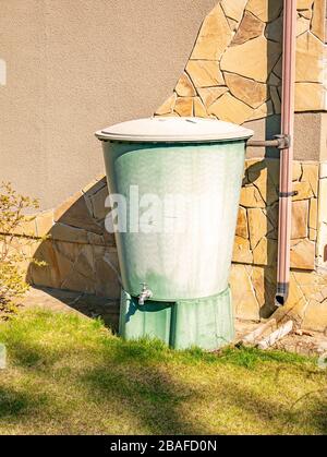 Grand réservoir d'eau en plastique avec robinet dans le jardin. Banque D'Images