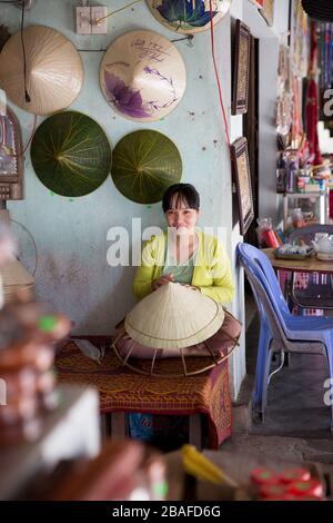 Une femme vietnamienne faisant des chapeaux coniques à Hue Banque D'Images