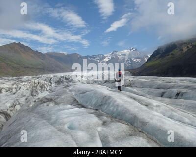 Alpiniste ou homme touristique randonnée sur glace sur le glacier Svinafellsjökull dans le parc national Vatnajökull, près du glacier Skaftafell en Islande avec b Banque D'Images