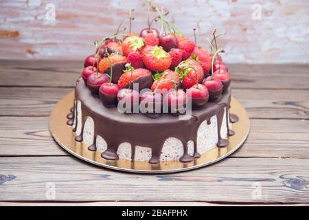 Cheesecake au chocolat fondu et aux baies fraîches, fraises, cerises, framboises. Banque D'Images