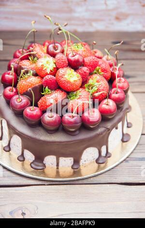 Cheesecake au chocolat fondu et aux baies fraîches, fraises, cerises, framboises. Banque D'Images