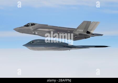 Un avion de chasse furtif F-35 A de l'armée de l'air royale des Pays-Bas et un bombardier Spirit B-2 A de l'armée de l'air américaine affecté à la 509ème Escadre Bomb, volent en formation pendant les opérations aériennes à l'appui de la Force opérationnelle de bombardement Europe 20-2 le 18 mars 2020 au-dessus de la mer du Nord. Banque D'Images