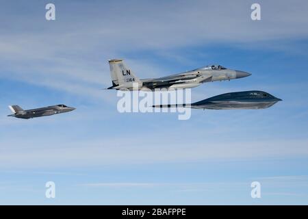 Un avion de chasse furtif F-35 A de la Royal Netherlands et un avion de chasse F-15 C Eagle de la U.S. Air Force en formation aux côtés d'un bombardier B-2 A Spirit assigné à la 509ème Escadre Bomb, lors d'opérations aériennes à l'appui de la Force opérationnelle de bombardement Europe 20-2 le 18 mars 2020 au-dessus de la mer du Nord. Banque D'Images