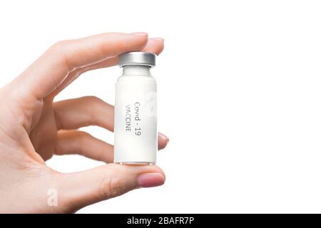 Main de la jeune femme tenant une petite bouteille avec un nouveau vaccin contre covid19 sur fond blanc avec copyspace sur la droite Banque D'Images