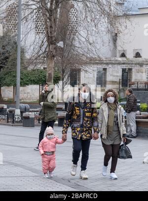 Istanbul, Turquie, parents avec un enfant portant des masques de protection contre le virus Corona (COVID-19) marchant dans la rue vide Banque D'Images
