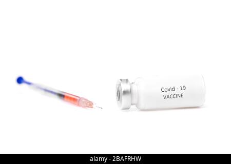 Seringue et petit flacon avec nouveau vaccin contre le covid19 posé sur le bureau dans un laboratoire médical ou scientifique sur fond blanc Banque D'Images