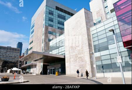 Toronto Women's College Hospital dans la crise pandémique de Covid-19. Les gens portent des masques faciaux. Le centre d'évaluation des blancs est dans la tente blanche en arrière-plan, le 25 mars 2020 Banque D'Images