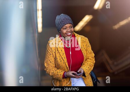 Jeune femme avec smartphone dans un quartier urbain Banque D'Images