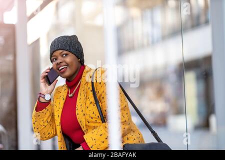 Jeune femme avec smartphone dans un quartier urbain Banque D'Images