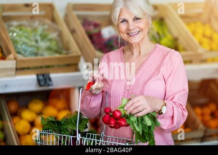 Femme shopping dans une petite épicerie Banque D'Images
