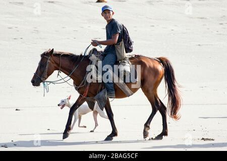 Un cow-boy nicaraguayen qui monte sur la plage le matin. Banque D'Images