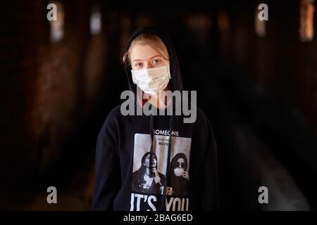 Donetsk / Russie / 3 mars 2020, petite fille en masque médical pendant la quarantaine dans un bâtiment détruit Banque D'Images