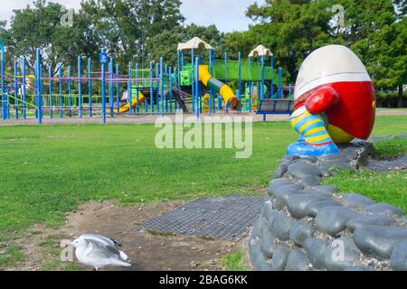 Tauranga Memorial Park aire de jeu pour enfants avec Humpty-Dumpty assis sur un mur bas donnant sur des équipements de jeu désertés comme les gens sont commandés de rester Banque D'Images