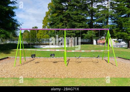 Des balançoires aux couleurs vives sont délaissées dans le parc commémoratif de Tauranga. Le terrain de jeu pour enfants est déserté alors que les gens sont commandés de rester à la maison pendant le maintien du covid-19 Banque D'Images