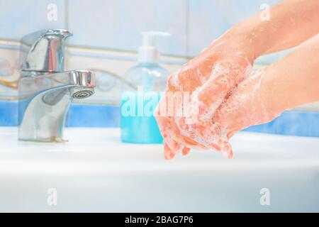 Se laver les mains avec du savon et de l'eau. Mains sur l'évier avec du savon. Mesures de protection contre la maladie du coronavirus COVID-19. Mains de nettoyage, mains de lavage Banque D'Images