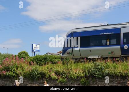 Train de banlieue NIR Translink CAF quittant la gare de Holywood dans le comté. Les passagers débarqués marchant le long de la bankment ferroviaire. Banque D'Images