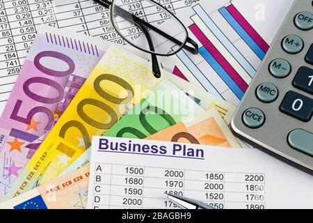 Euro Banknoten und Muenzen, Businessplan, Taschenrechner, Brille, Banque D'Images