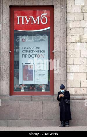 Un homme âgé portant un masque protecteur comme mesure préventive contre le Coronavirus COVID-19 se trouve à l'extérieur d'un bureau de banque à Kiev.le gouvernement ukrainien a introduit une urgence nationale pendant 30 jours et a prolongé la quarantaine contre la propagation du coronavirus COVID-19 en Ukraine jusqu'au 24 avril 2020. À 10 h, le 27 mars 2020, 218 cas de COVID-19 confirmés en laboratoire en Ukraine, dont 5 mortels et 4 se sont redressés. Au cours de la journée, 62 nouveaux cas ont été enregistrés en Ukraine. Banque D'Images