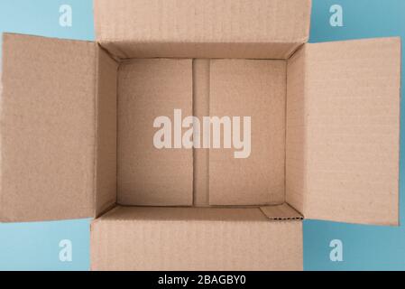 En haut au-dessus de la vue rapprochée photo de la boîte vide non emballée sur fond bleu avec espace de copie vide Banque D'Images