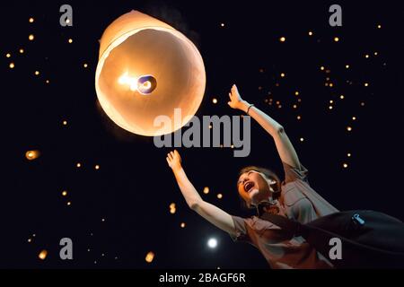 Chiang Mai, Thaïlande; 11 novembre 2016: Une fille avec des lanternes flottantes lumineuses en papier à Loi Krithong Banque D'Images