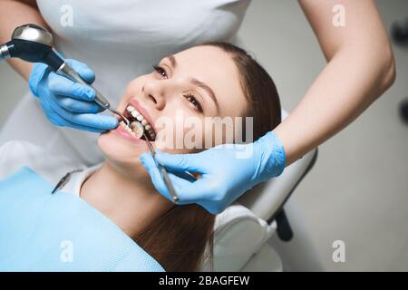 Jeune femme traitant les dents en clinique photo Banque D'Images