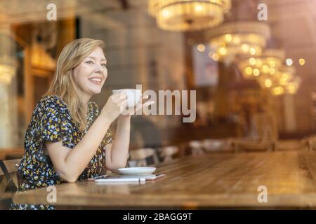 Esquisse de designer féminine avec tablette numérique et stylet au café Banque D'Images