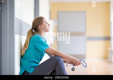 Infirmière féminine fatiguée dans le couloir de l'hôpital Banque D'Images