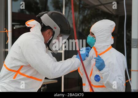 San Mateo, États-Unis. 27 mars 2020. Un membre de la Garde d'État de Californie et un membre du personnel de la California Emergency Medical Service Authority s'adaptent à un équipement de protection individuelle avant de traiter les patients COVID-19 le 27 mars 2020 dans le comté de San Mateo, en Californie. Crédit : Eddie Siguenza/US Army/Alay Live News Banque D'Images