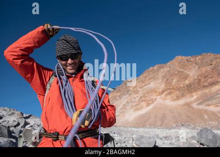 Un homme enroulant une corde autour de sa tête tout en montant Pico de Orizaba Banque D'Images