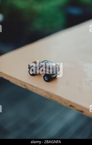 Une voiture miniature jouet sur une table dans le jardin. Banque D'Images