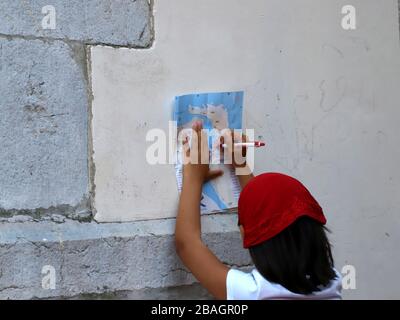 Petite fille avec écharpe rouge sur sa tête marquant l'itinéraire d'un voyage sur une carte Banque D'Images