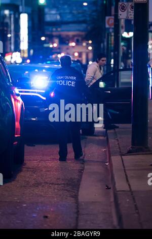 CENTRE-VILLE DE VANCOUVER, C.-B., CANADA - 24 MARS 2020 : agents VPD arrêtant un jeune délinquant caucasien le mettant en menottes et le traitant Banque D'Images