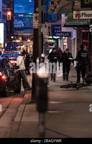 CENTRE-VILLE DE VANCOUVER, C.-B., CANADA - 24 MARS 2020 : agents VPD arrêtant un jeune délinquant caucasien le mettant en menottes et le traitant Banque D'Images