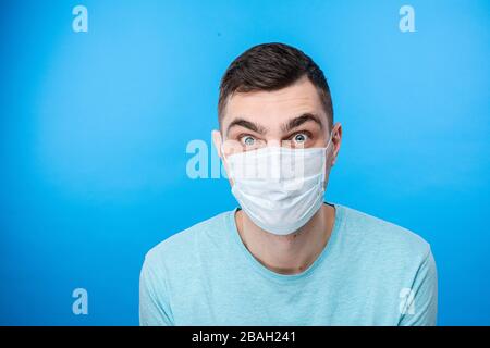 Homme effrayé dans un masque médical regardant dans l'appareil photo Banque D'Images