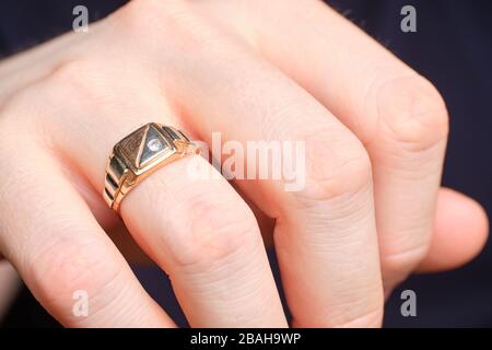 Anneau d'or sur un doigt d'homme. Gros plan. Banque D'Images