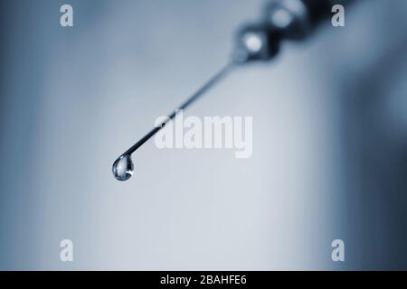seringue avec une goutte de médicament, photo macro Banque D'Images