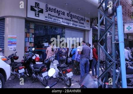 Cambodgiens, portant des masques pour le visage, attendant en ligne en dehors d'une pharmacie pour acheter des drogues pendant la pandémie de coronavirus, Phnom Penh, Cambodge. © Kraig Lieb Banque D'Images